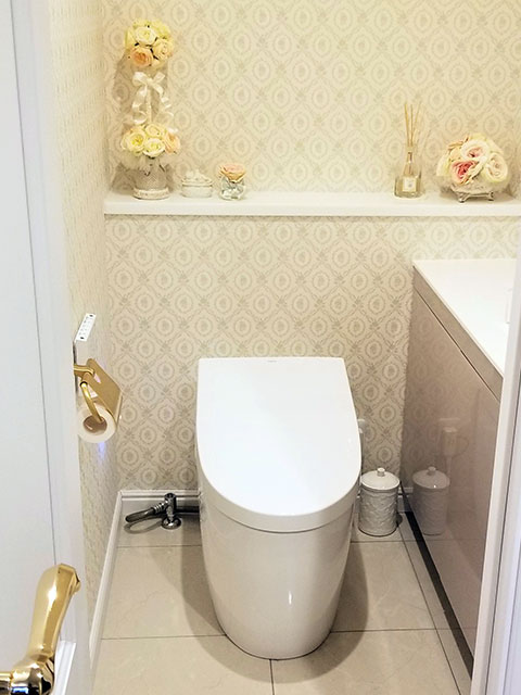 サイド収納の扉はスライド式で奥まで収納できます。手洗いは自動水栓、床は大理石調タイルです。